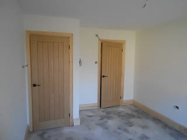 Freshly painted white room with oak doors and new skirting boards