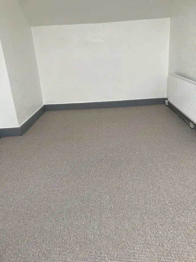 Bedroom with white walls and dark grey painted skirting boards